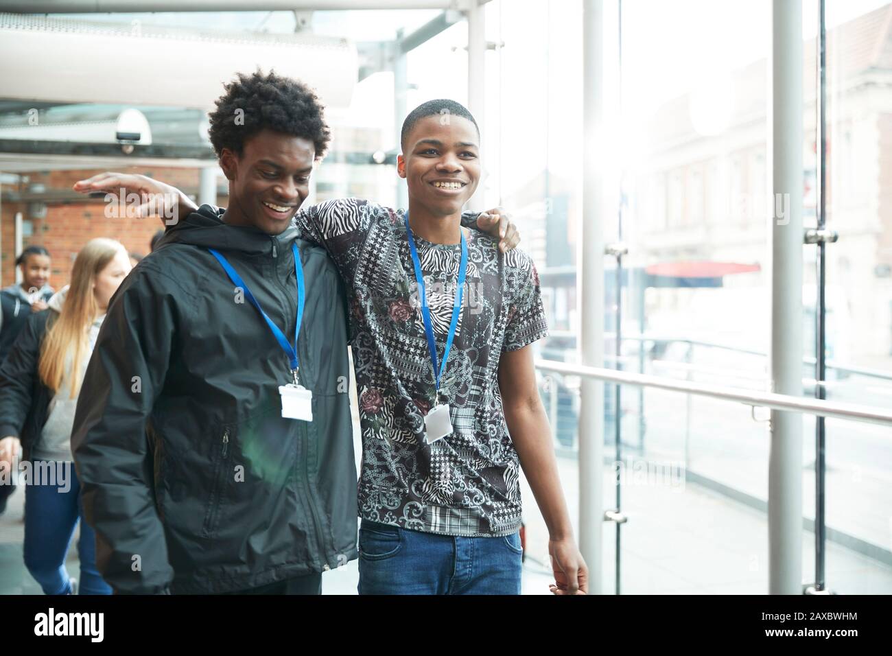 Fröhliche High-School-Freunde, die auf dem Flur spazieren gehen Stockfoto