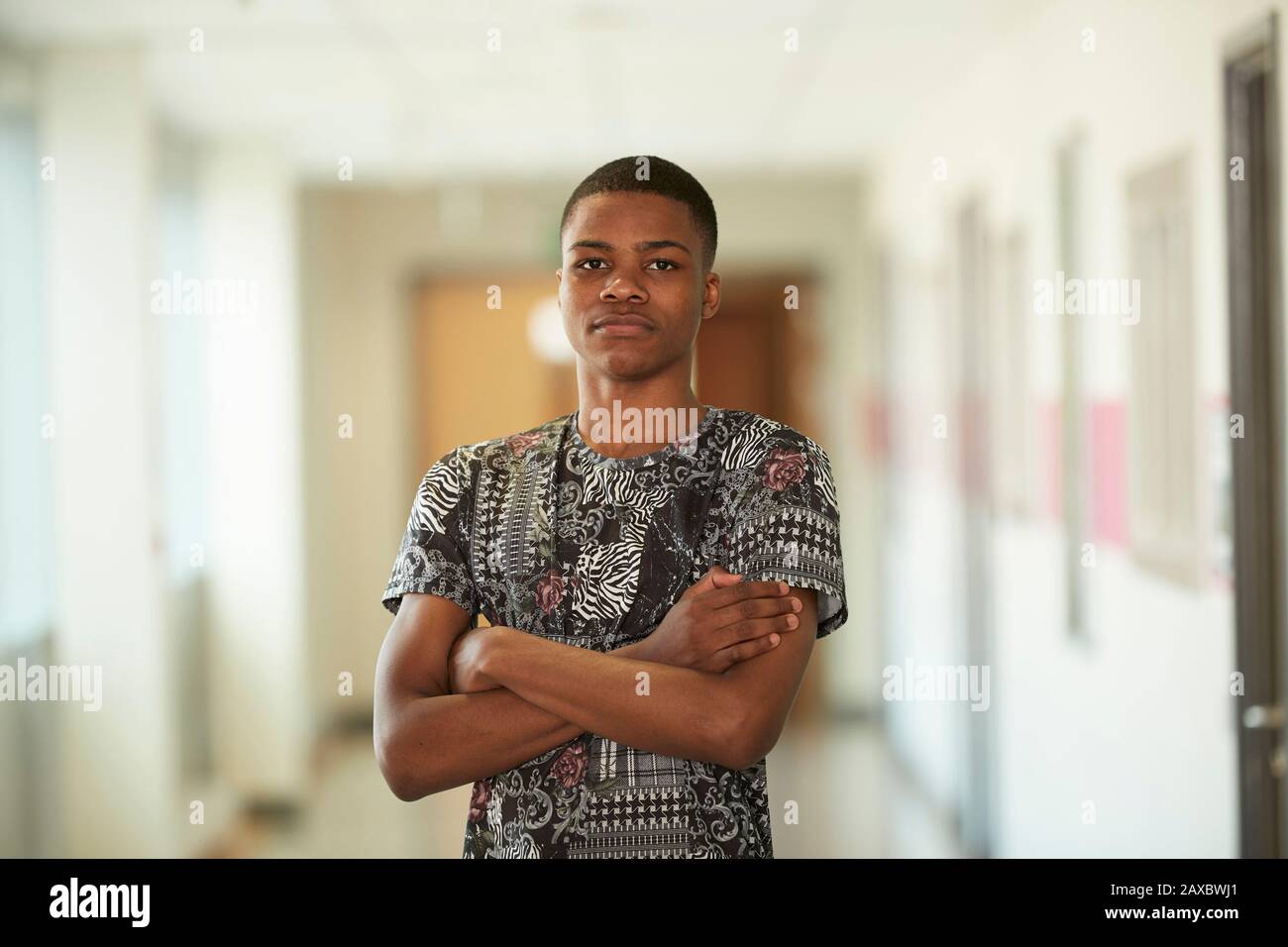 Portrait selbstbewusster ernster High-School-Junge im Korridor Stockfoto