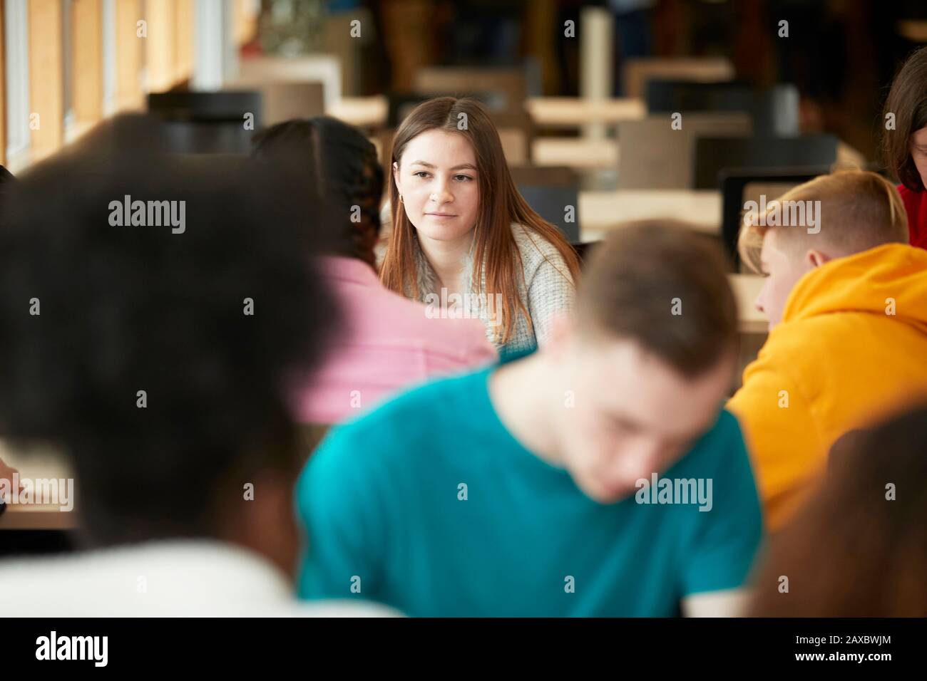 Junge Studentin im College, die Klassenkameradin hört Stockfoto