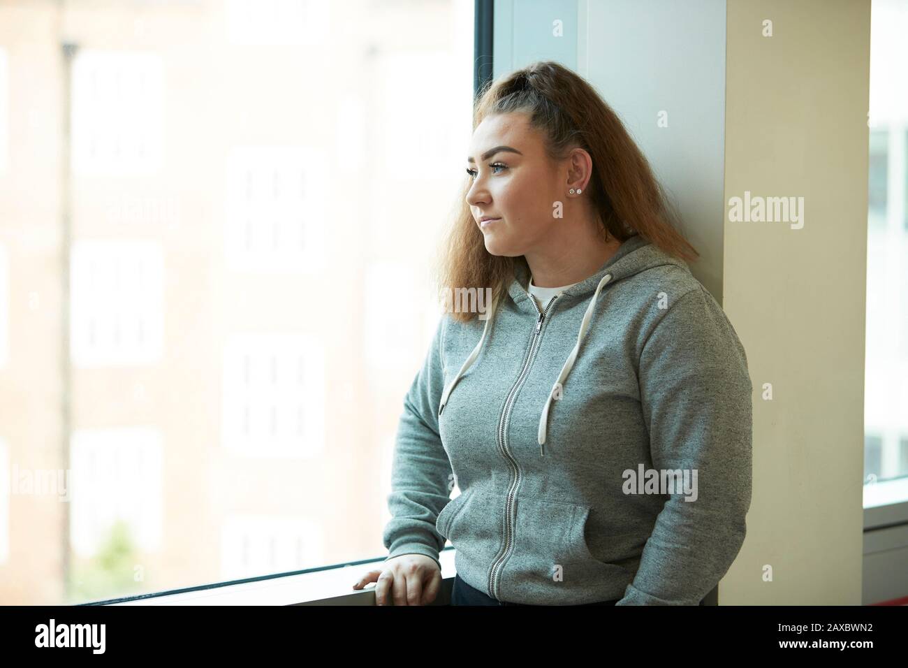 Nachdenkliches Teenager-Mädchen mit Blick auf das Fenster Stockfoto