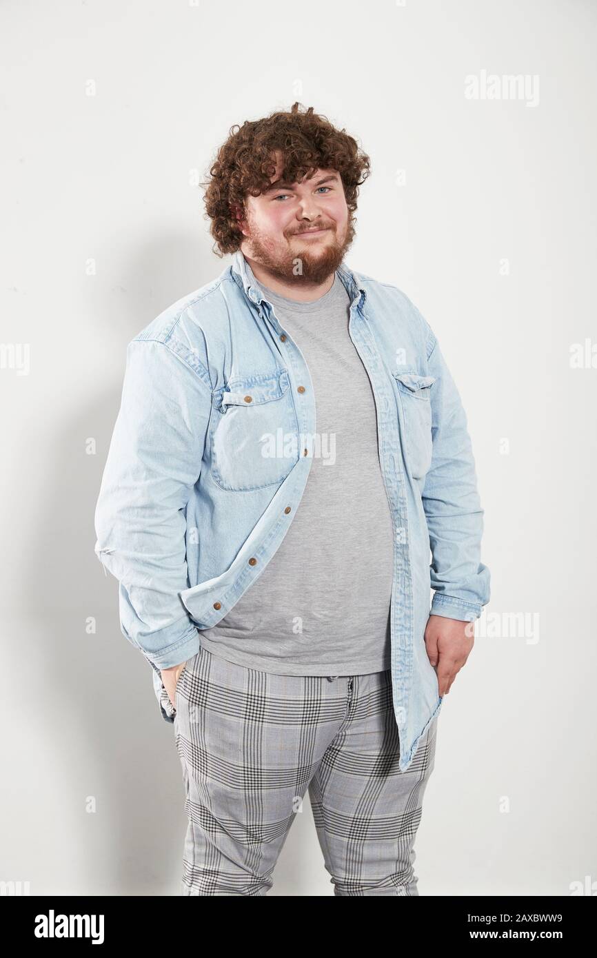 Portrait lächelnder junger Mann in Denimhemd und Plaid Hose Stockfoto