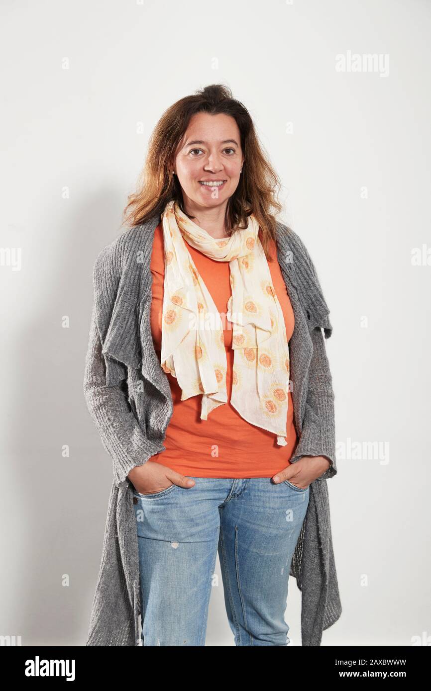 Portrait selbstbewusste Frau mit Schal Pullover und Jeans Stockfoto