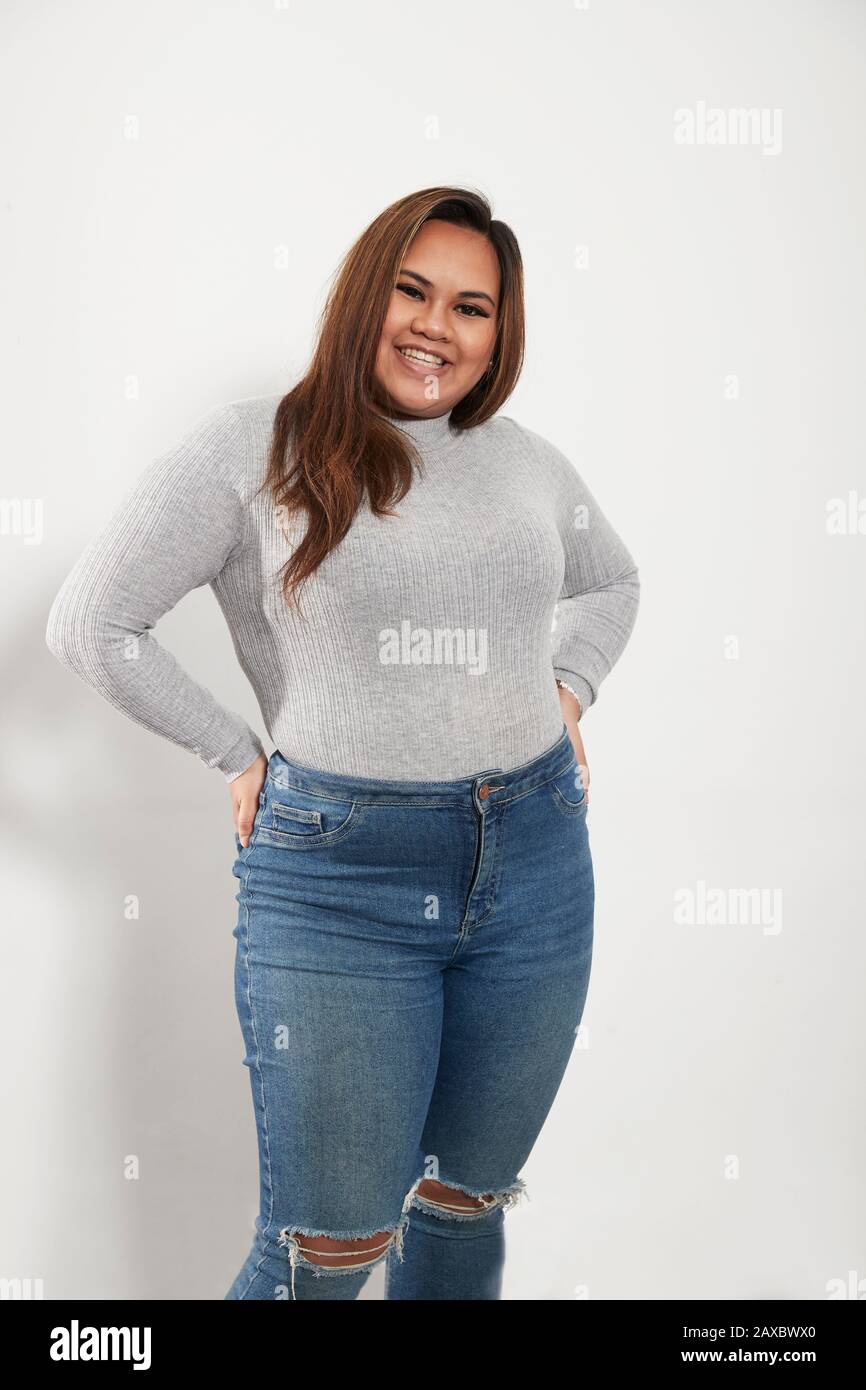 Portrait selbstbewusste junge Frau in Pullover und Jeans Stockfoto