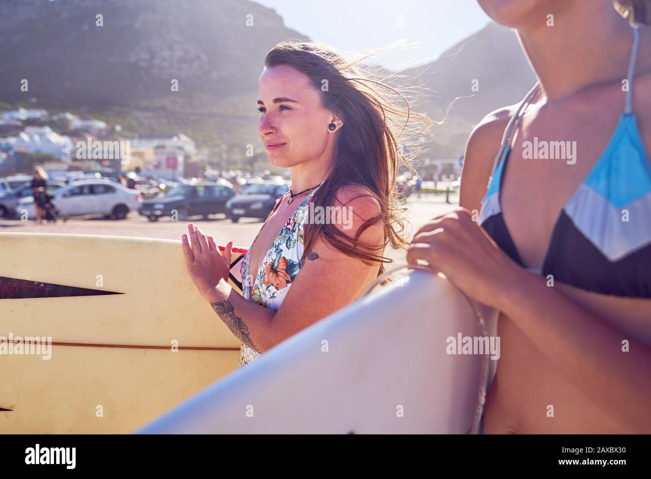 Selbstbewusster weiblicher Surfer mit Surfbrett am sonnigen Strand Stockfoto