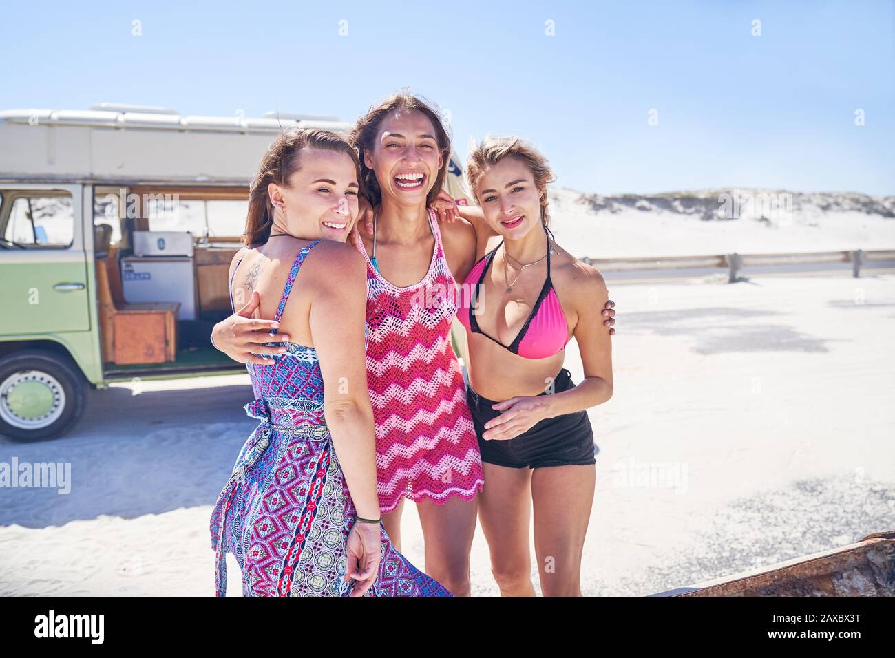 Portrait unbeschwerte junge Frauen Freunde am sonnigen Sommerstrand Stockfoto