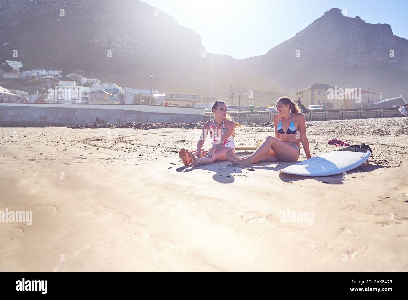 Junge Frauen surfern mit Surfbrettern am sonnigen Strand Stockfoto