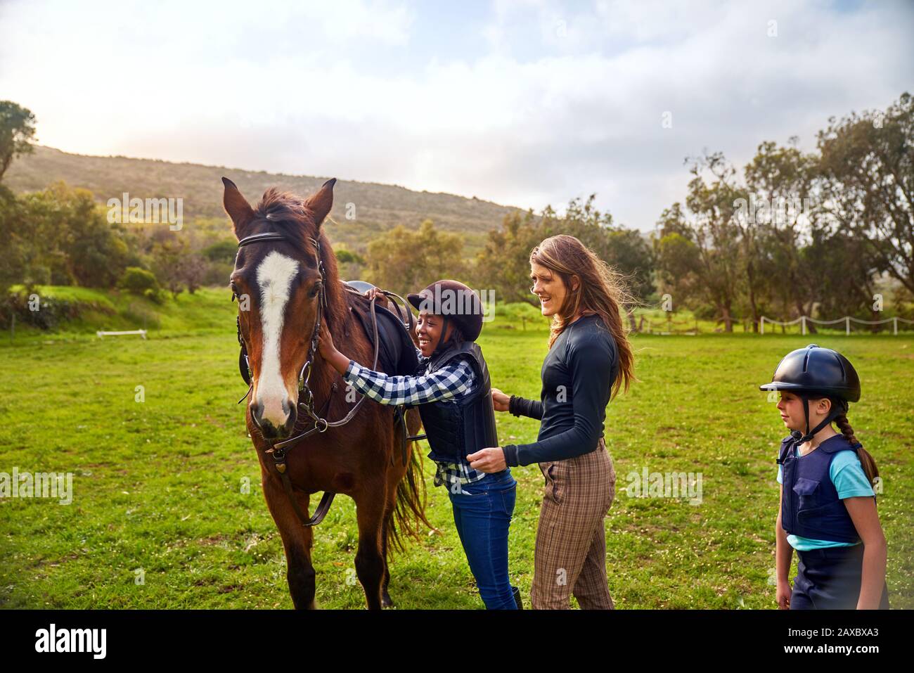 Glückliches Mädchen, das Pferd beim Reitunterricht streichelt Stockfoto