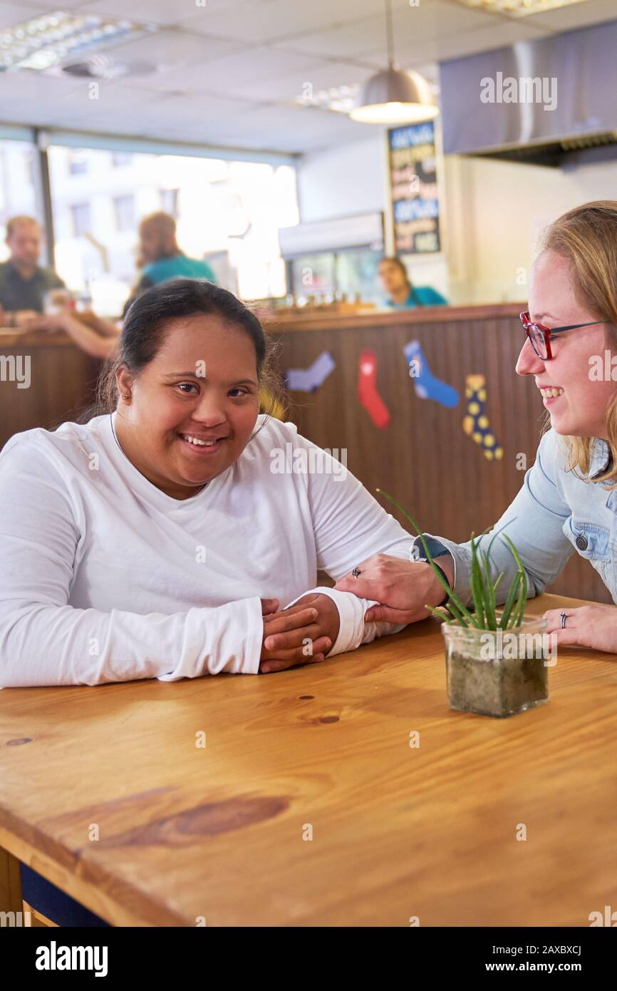 Portrait fröhliche junge Frau mit Down-Syndrom im Café Stockfoto