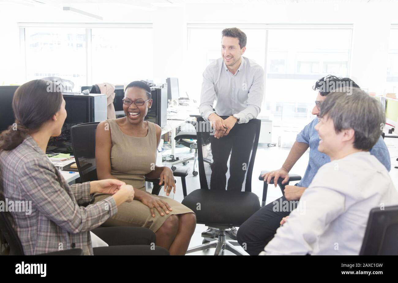 Glückliche Geschäftsleute sprechen, treffen sich im offenen Büro Stockfoto