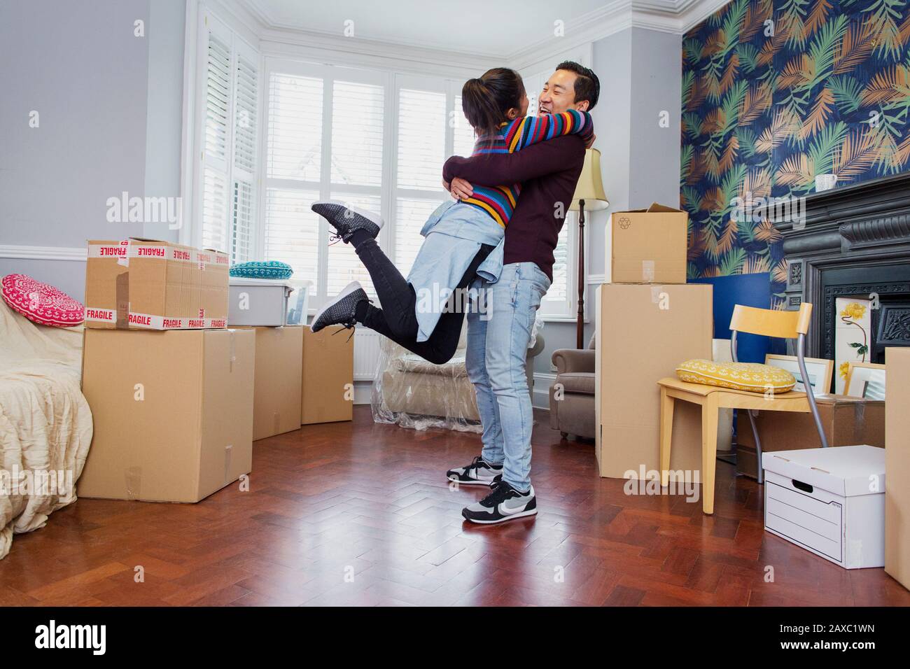 Glückliches, aufgeregtes Paar zieht in neue Wohnung Stockfoto