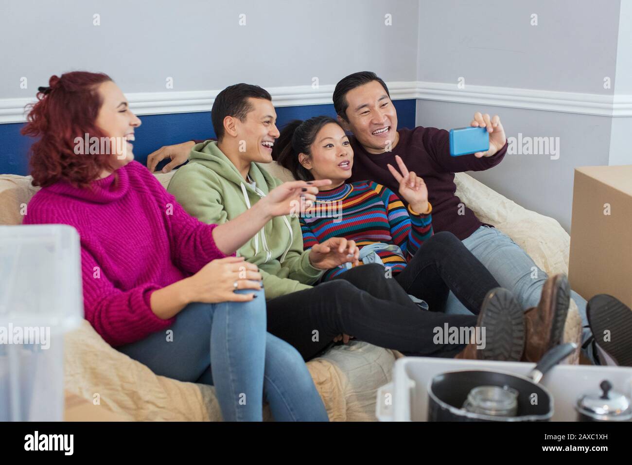 Fröhliche Freunde, die eine Pause von der Bewegung machen und selfie auf dem Sofa nehmen Stockfoto