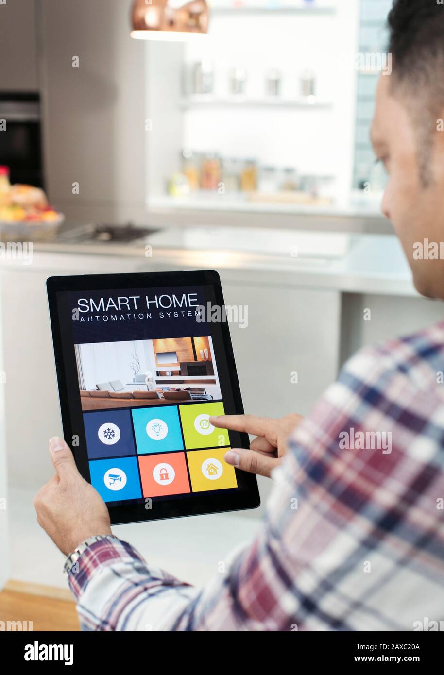 Mann steuert Smart Home Navigationssystem vom digitalen Tablet in der Küche Stockfoto