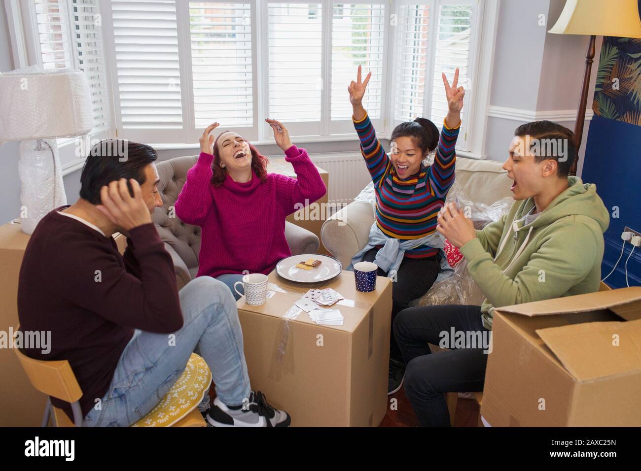 Glückliche Freunde, die eine Pause vom bewegen und Spielen von Karten einlegen Stockfoto