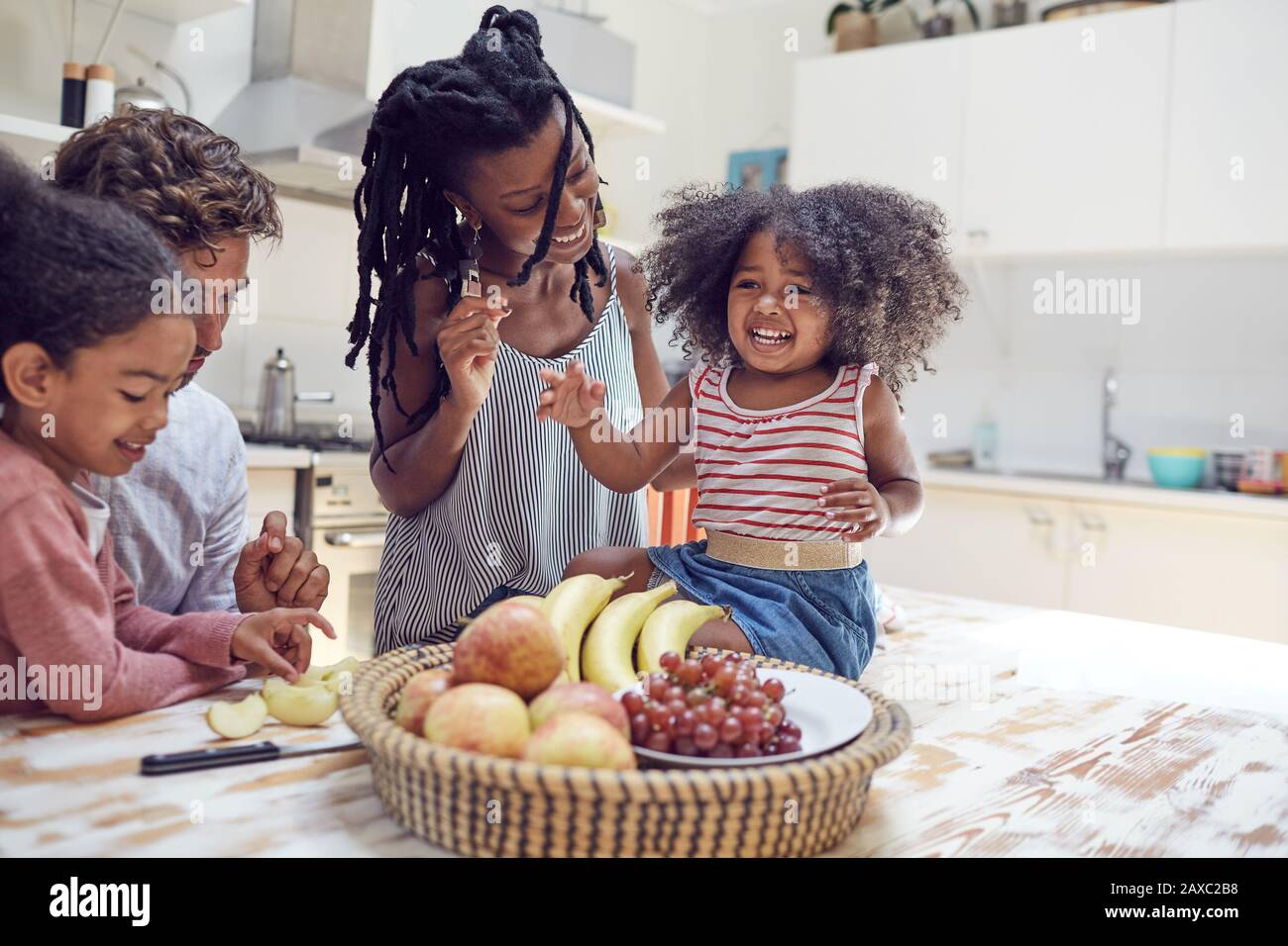 Junge Familie, die Obst in der Küche isst Stockfoto