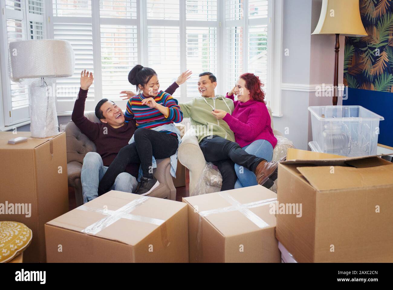 Fröhliche Freunde, die eine Pause von Bewegung und Feiern einlegen Stockfoto