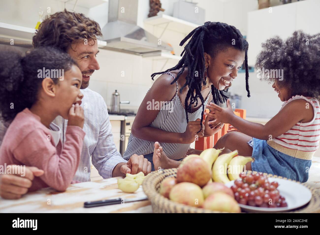 Junge Familie, die Obst auf dem Tisch isst Stockfoto