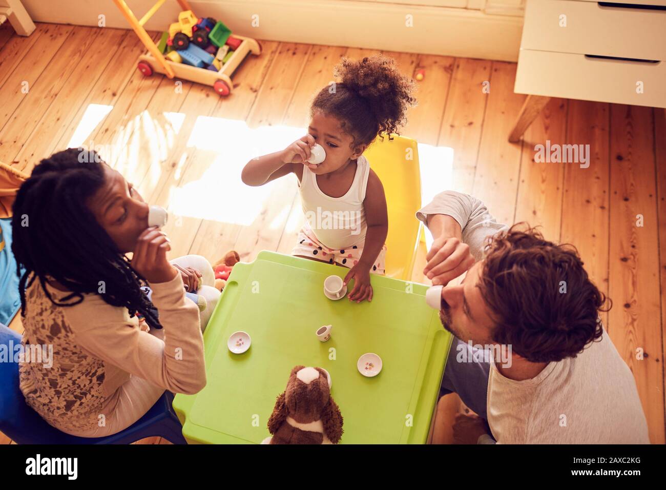 Junge Familie genießt imaginäre Teeparty Stockfoto