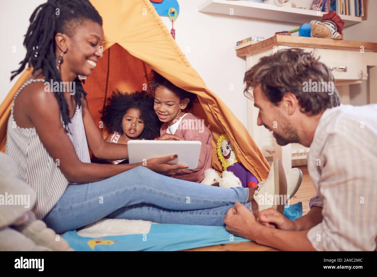 Junge Familie mit digitalem Tablet auf Teepee Stockfoto