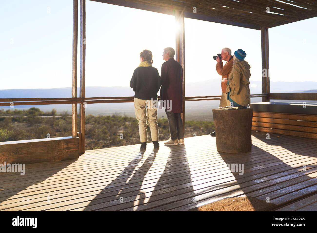 Freunde, die vom sonnigen Balkon der Safari-Lodge aus den Blick genießen Stockfoto