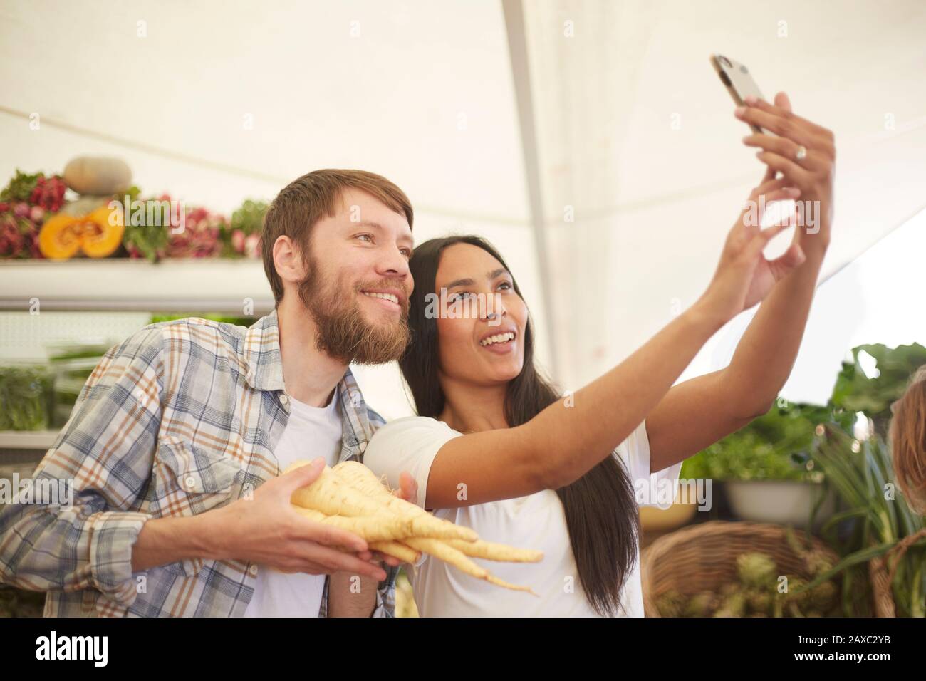 Lächelndes Paar, das selfie auf dem Bauernmarkt mitnimmt Stockfoto