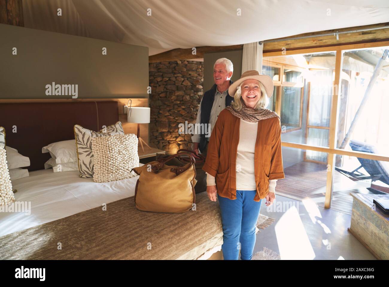Portrait glückliches älteres Paar, das im Hotelzimmer der Safari-Lodge ankommt Stockfoto