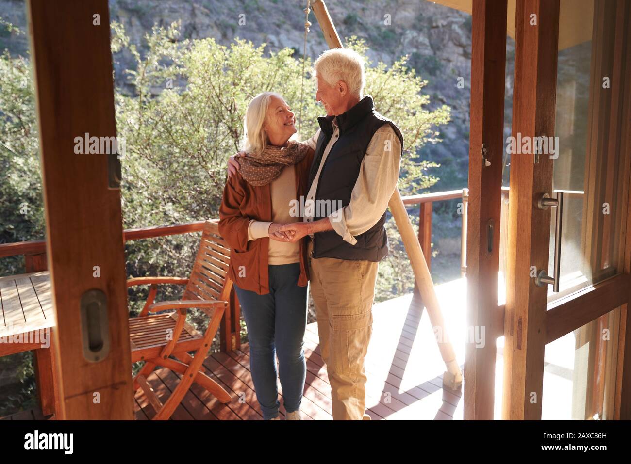 Fröhliches liebevolles Senioren-Paar auf dem sonnigen Safari-Lodge-Balkon Stockfoto