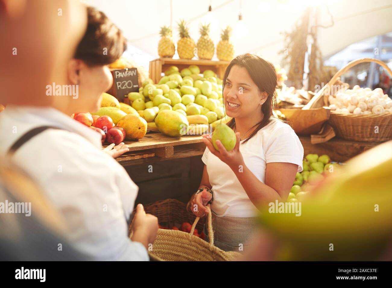 Frau, die arbeitet und Birnen auf dem Bauernmarkt arrangiert Stockfoto