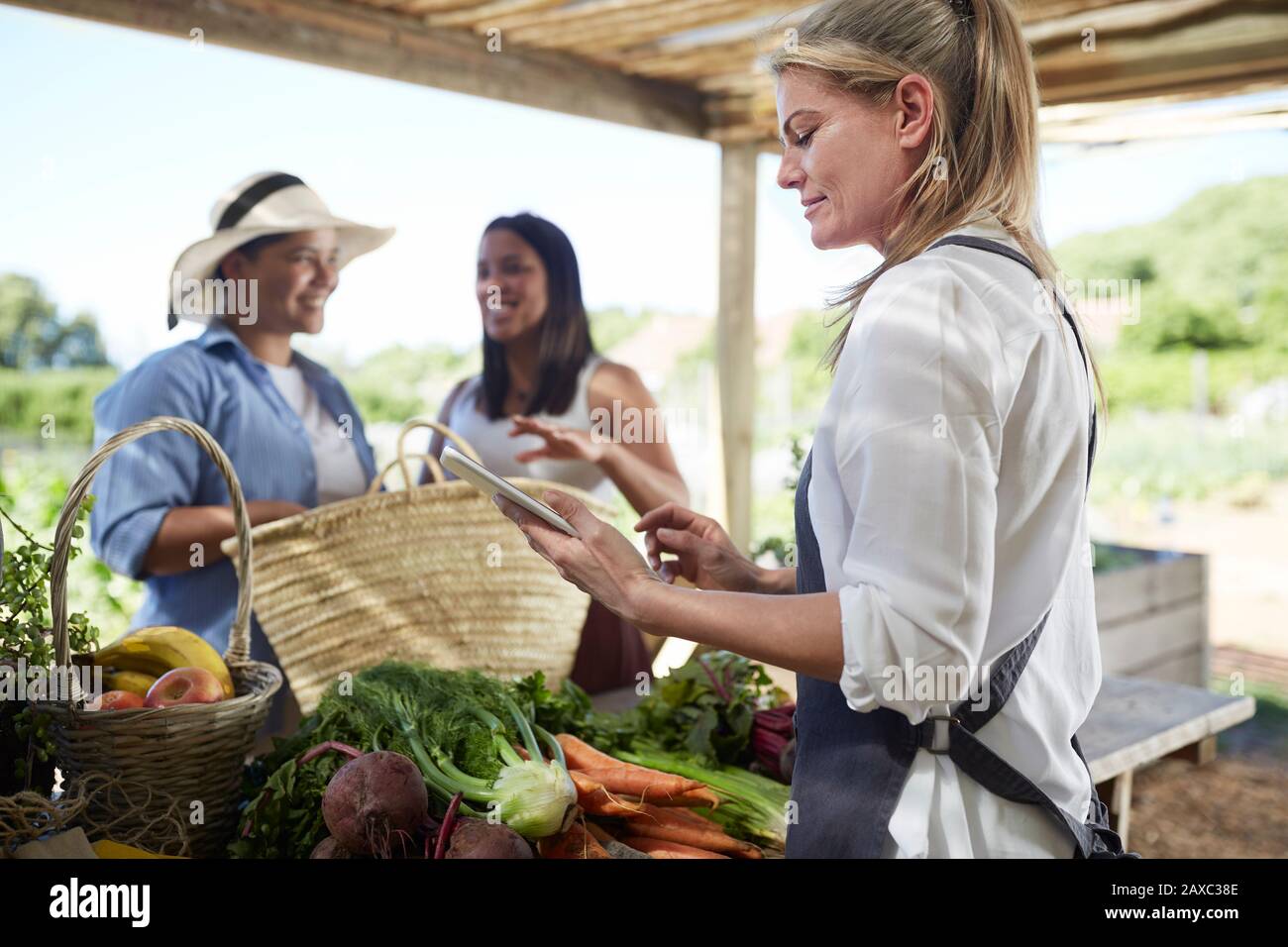 Frau mit digitaler Tablette, die auf dem Bauernmarkt arbeitet Stockfoto