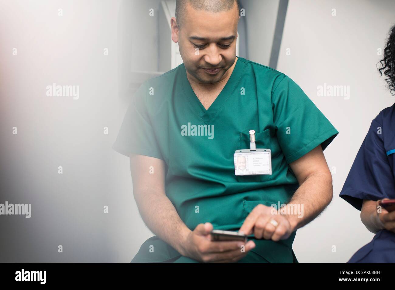 Männlicher Chirurg mit Smartphone Stockfoto