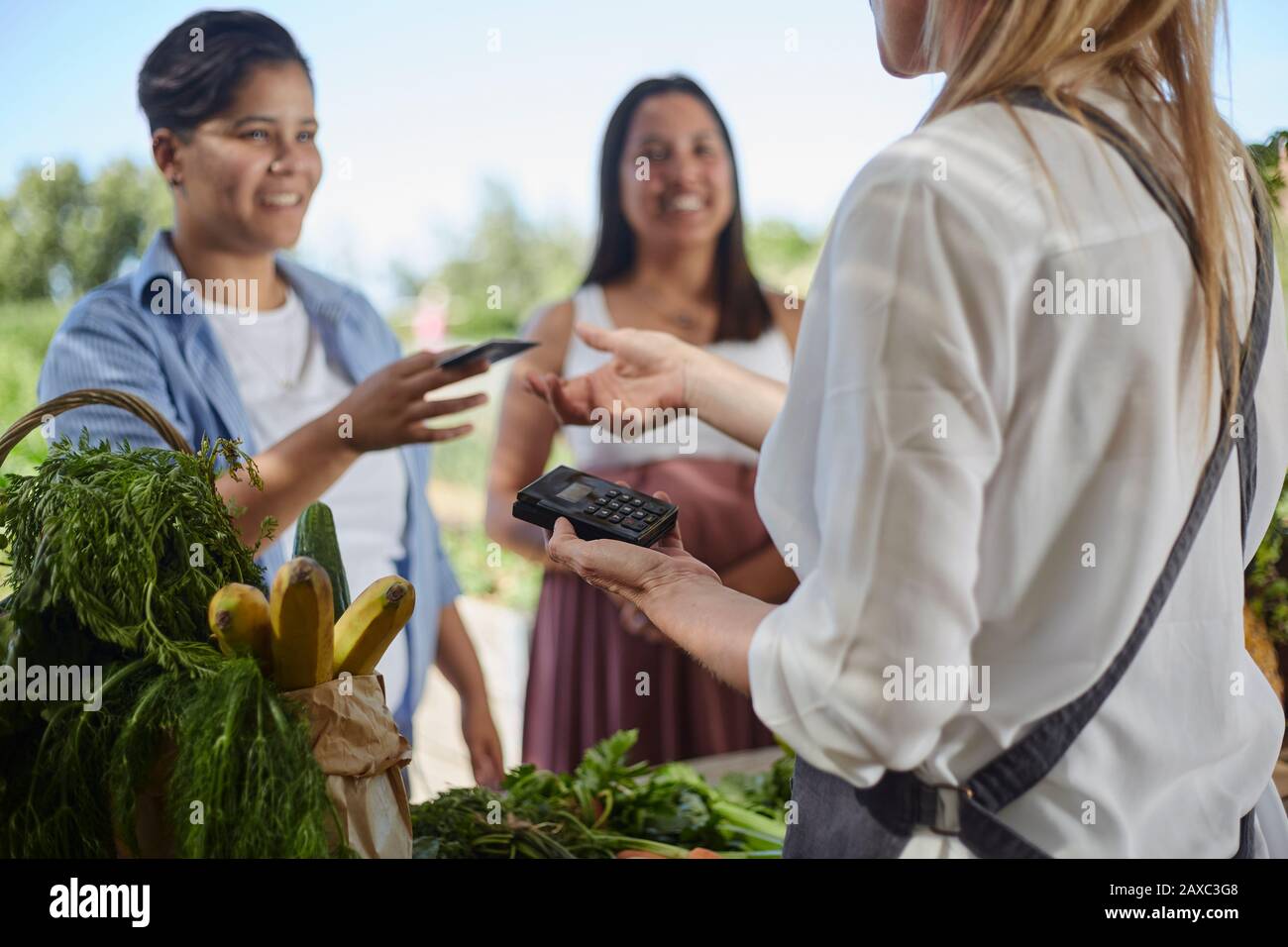 Frau, die mit Kreditkarte auf dem Bauernmarkt bezahlt Stockfoto