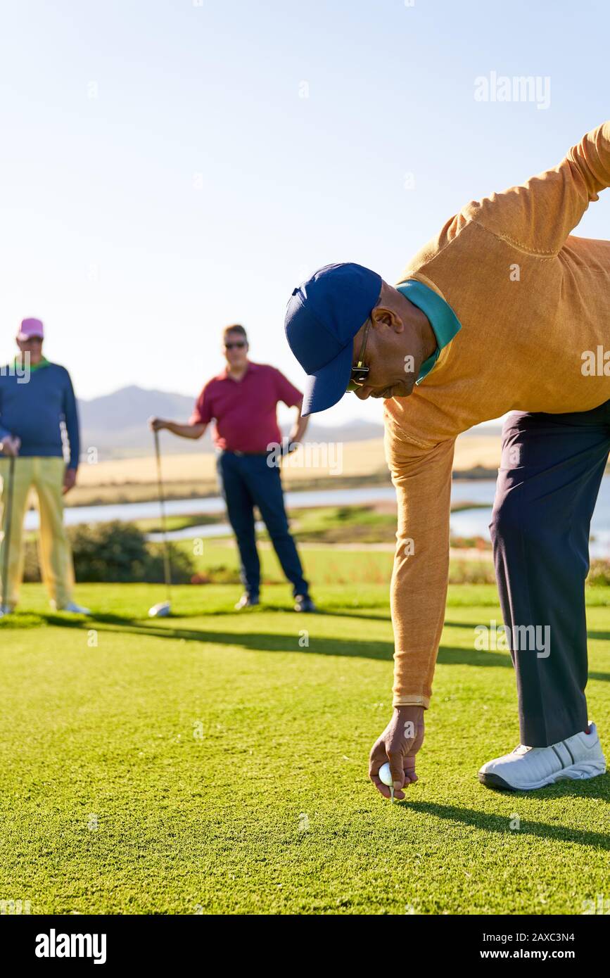 Männlicher Golfer, der sich am sonnigen Golf-T-Stück-Kasten abzweigen vorbereitet Stockfoto