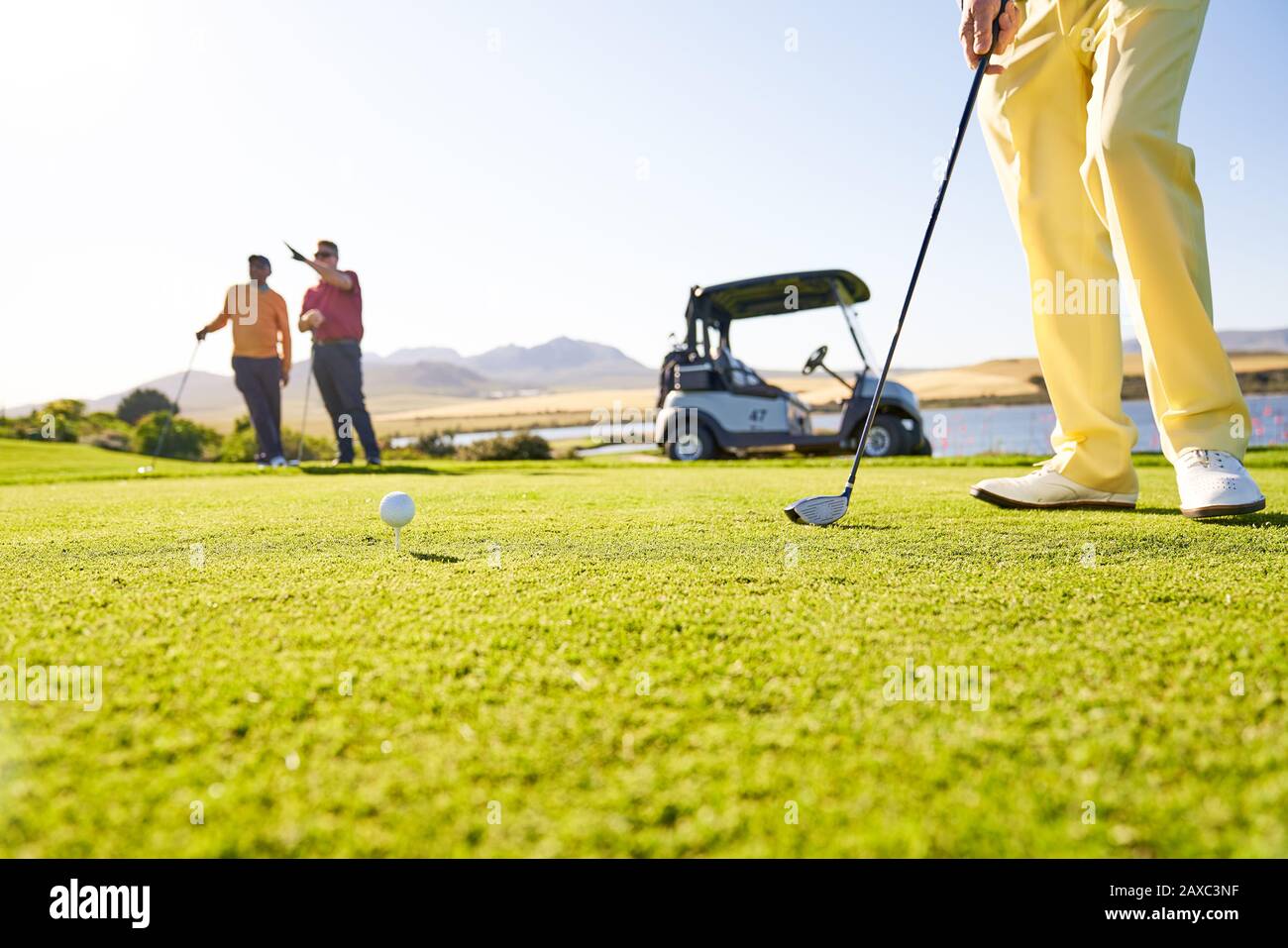 Golfer, der sich am sonnigen T-Stück abzweigen vorbereitet Stockfoto