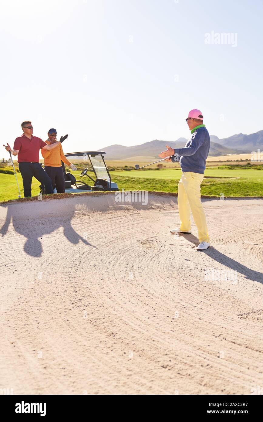 Männlicher Golfer im Bunker auf sonnigen Golfplatz Stockfoto