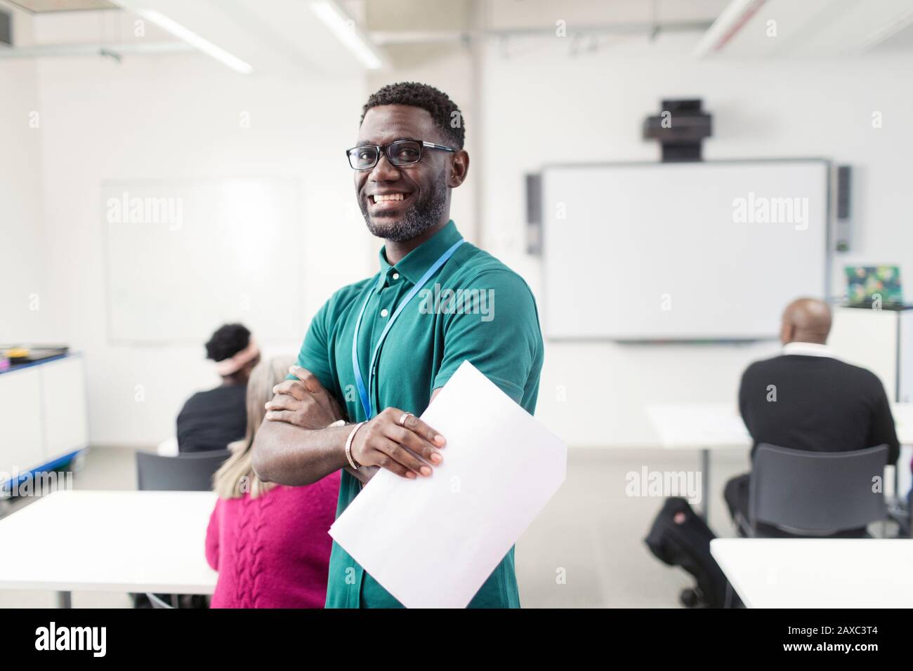 Portrait lächelnde, selbstbewusste männliche Community College-Dozentin im Klassenzimmer Stockfoto