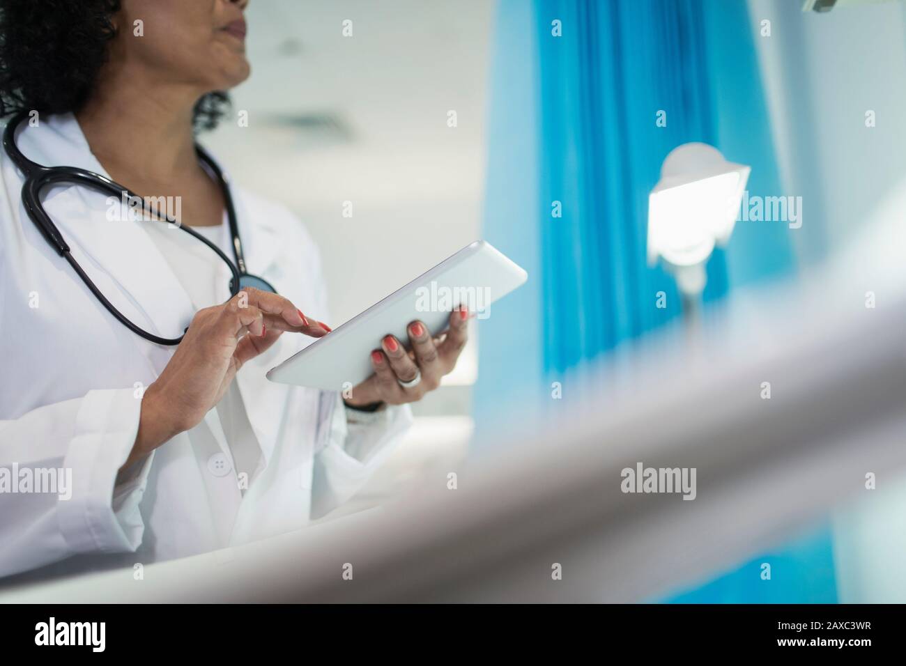 Ärztin mit digitaler Tablette im Krankenhauszimmer Stockfoto