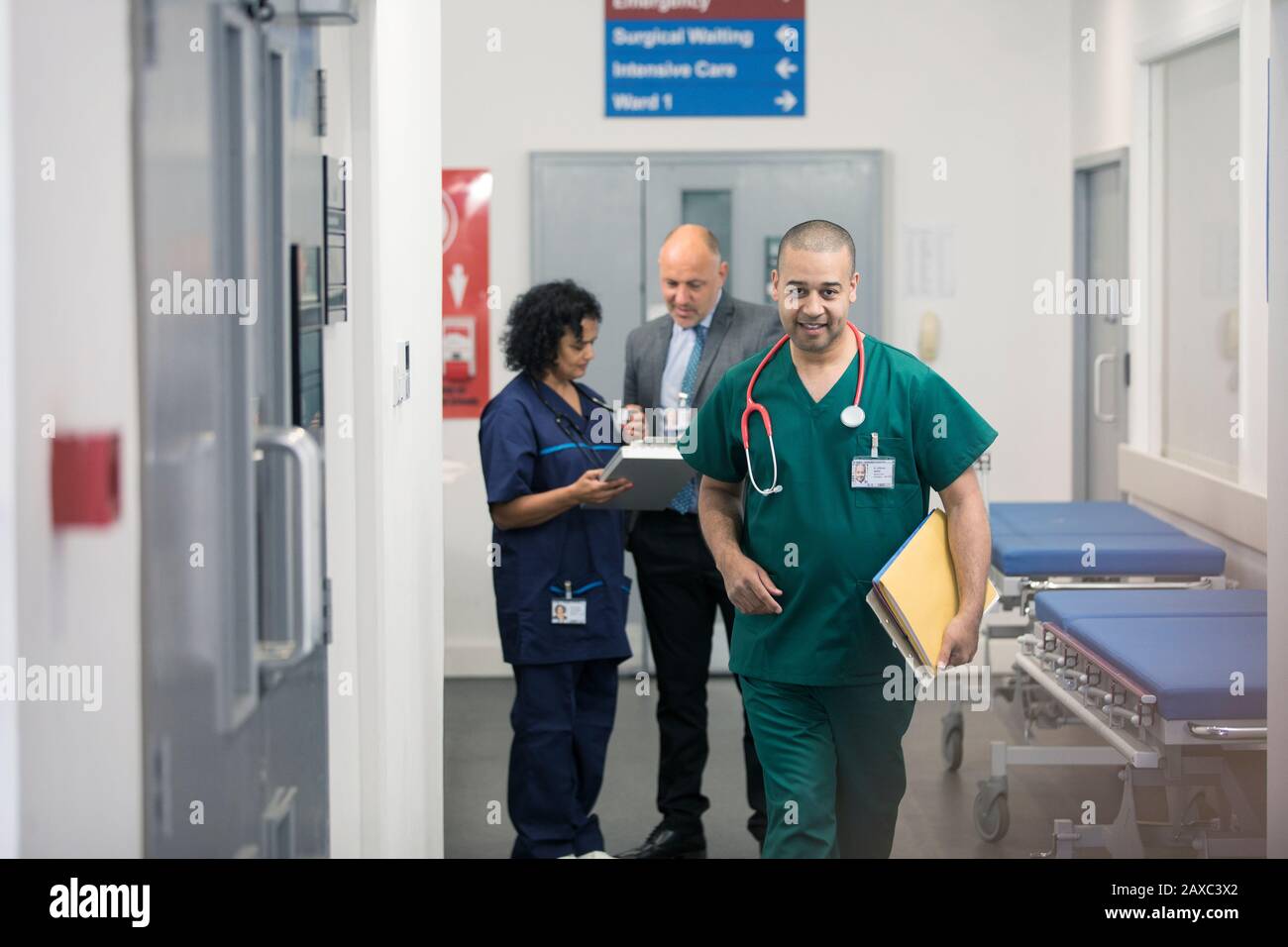 Männlicher Chirurg, der auf dem Krankenhausflur spazieren ging Stockfoto