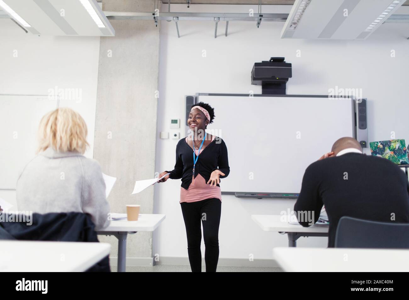 Lächelnder, fröhlicher Dozent der Community College, der die Lektion im Klassenzimmer führt Stockfoto