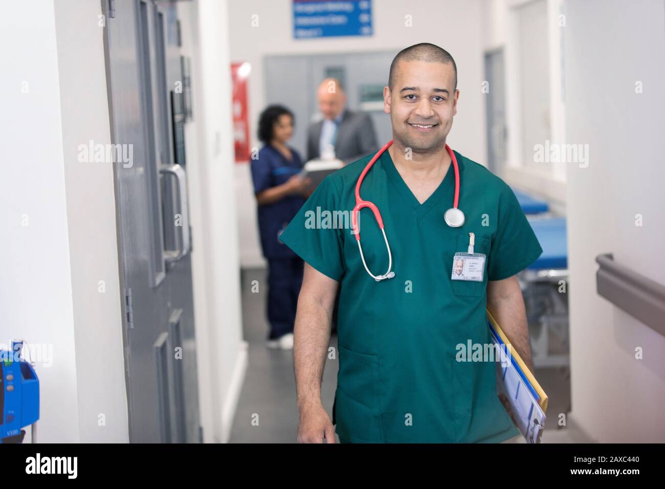 Portrait selbstbewusster männlicher Chirurg, der im Krankenhausflur spazieren geht Stockfoto