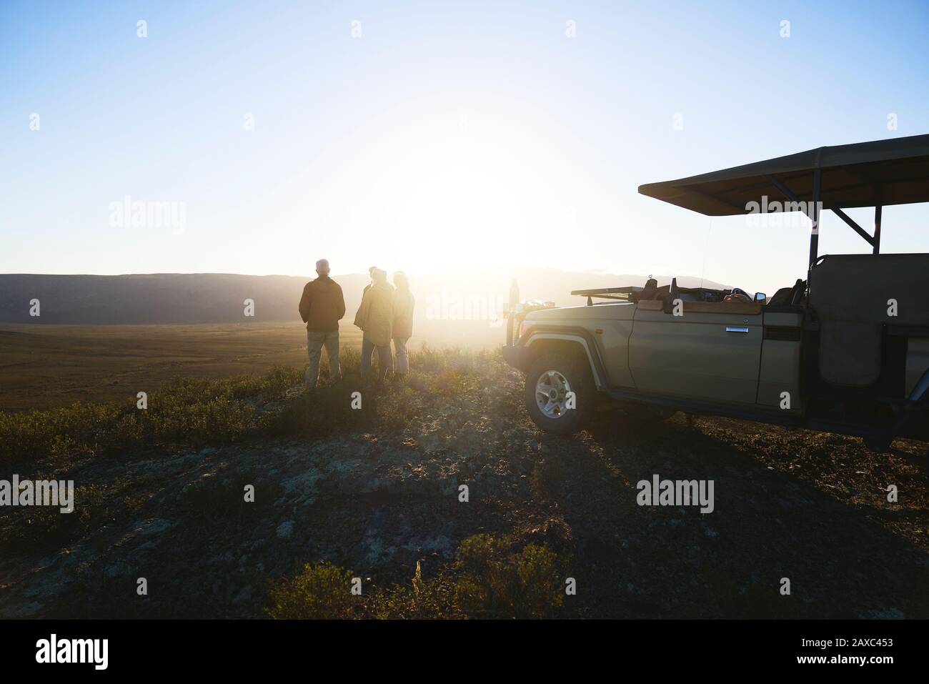 Safari-Tour-Gruppe und Geländewagen auf einem Hügel bei Sonnenaufgang Südafrika Stockfoto