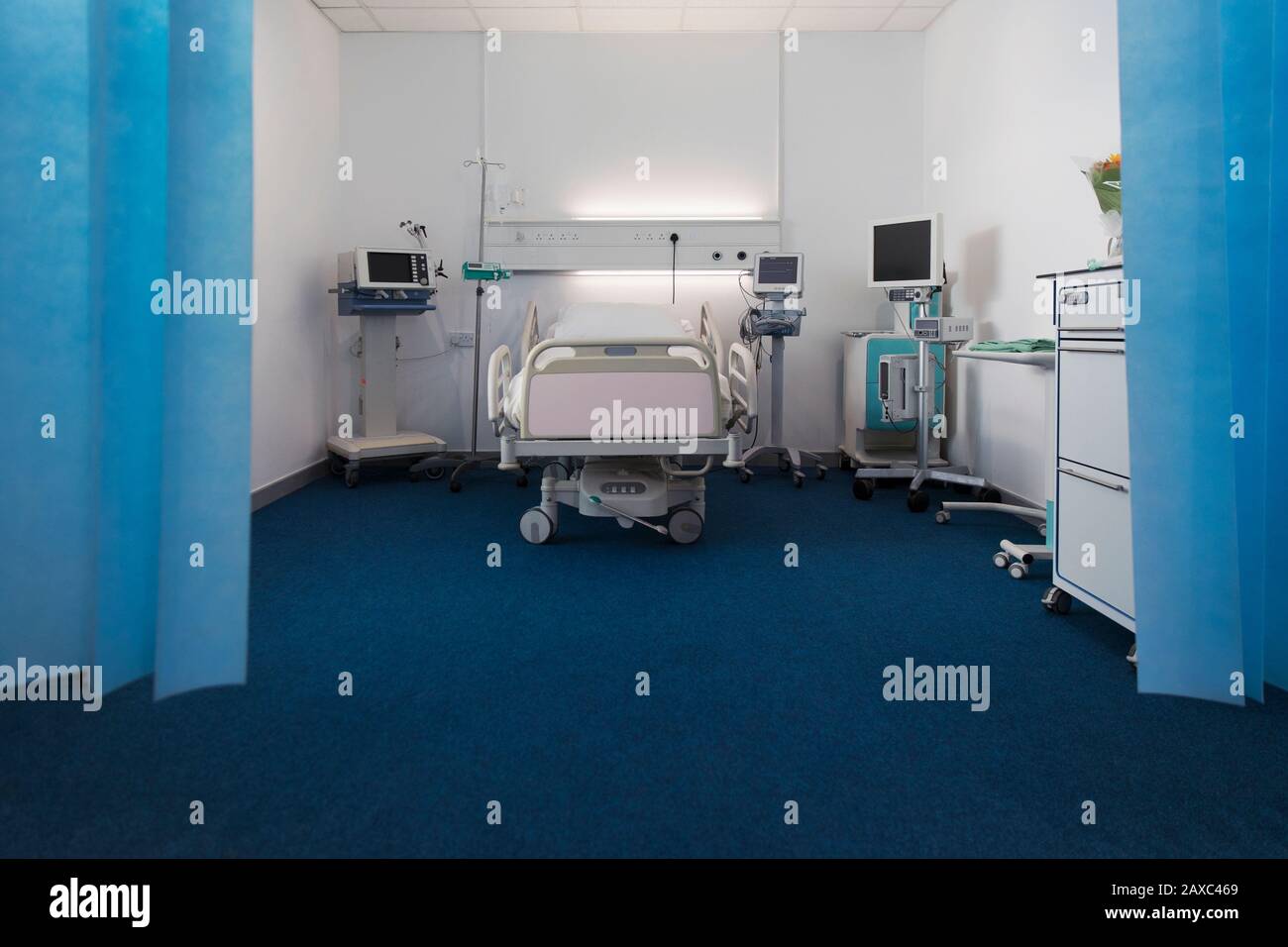 Leerstehendes Krankenhauszimmer mit Bett und medizinischen Geräten Stockfoto