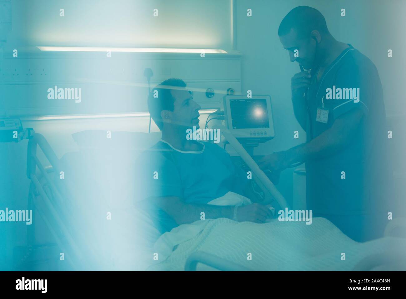 Krankenschwester mit Stethoskop, die den Patienten im Krankenhausbett untersucht Stockfoto