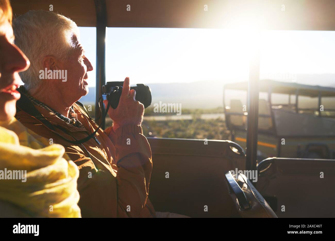 Älteres Paar mit Digitalkamera, das im Geländewagen einer Safari fährt Stockfoto
