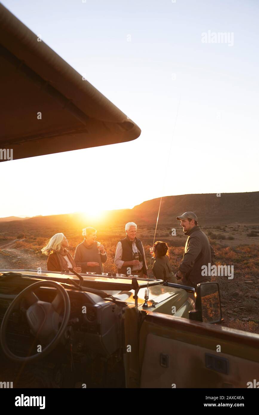 Safari-Tour-Gruppe, die Champagner bei Sonnenuntergang in Südafrika trinkt Stockfoto