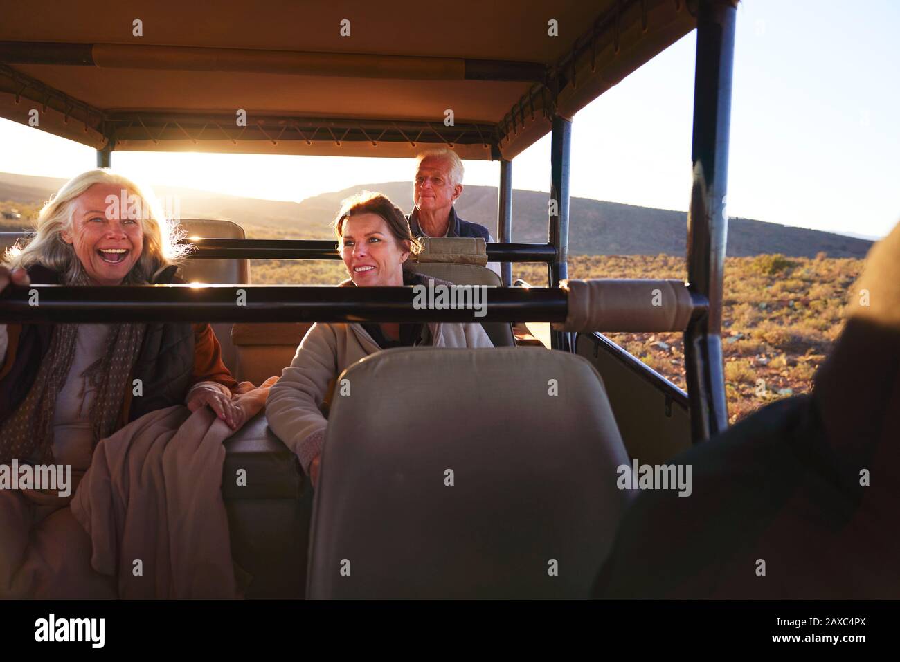Fröhliche Freunde, die im Geländewagen der Safari fahren Stockfoto