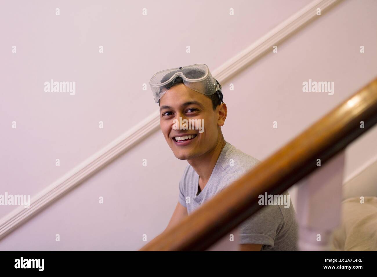 Portrait fröhlicher, selbstbewusster Mann mit Brille, der das Haus umstellt Stockfoto