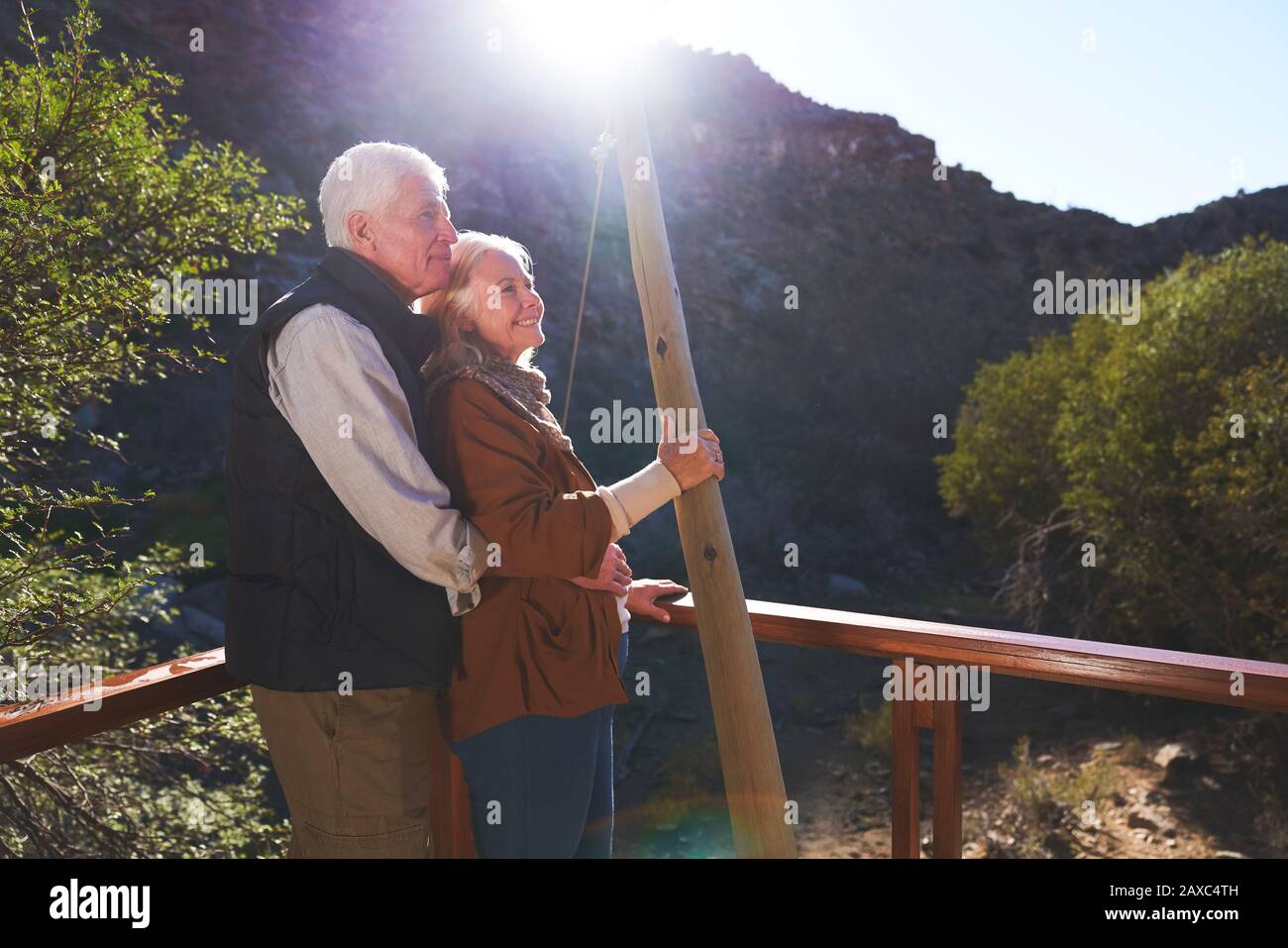 Glückliches älteres Paar, das sich auf dem sonnigen Balkon entspannen kann Stockfoto
