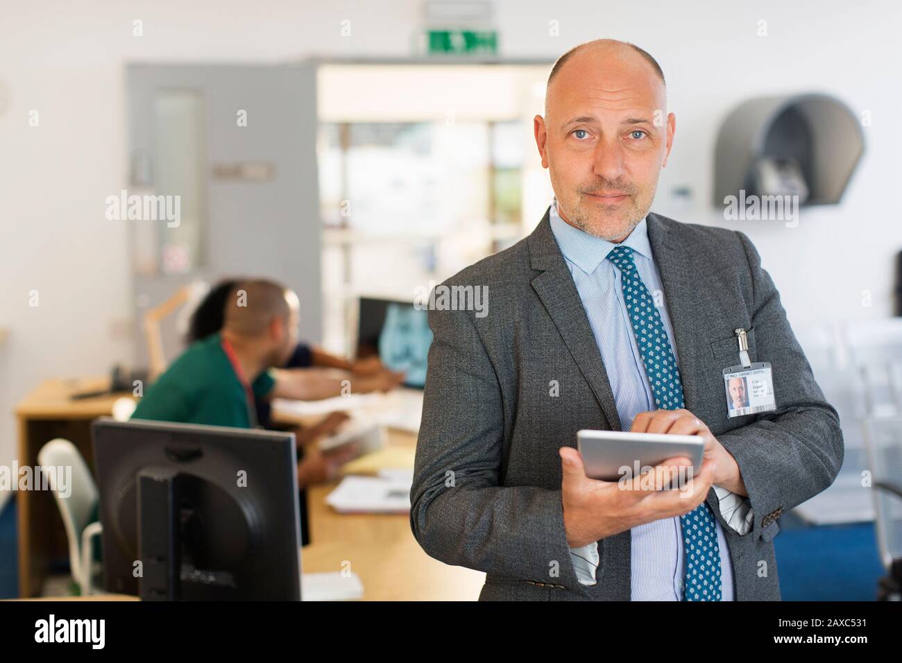 Portrait selbstbewusster männlicher Administrator mit digitalem Tablet in der Klinik Stockfoto