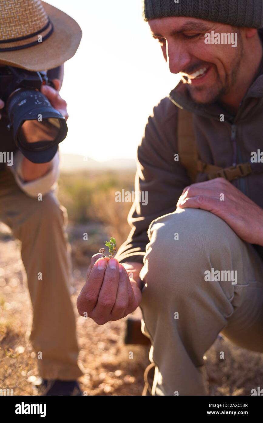 Lächelnder Safari-Reiseleiter, der dem Mann mit Digitalkamera die Anlage erklärt Stockfoto