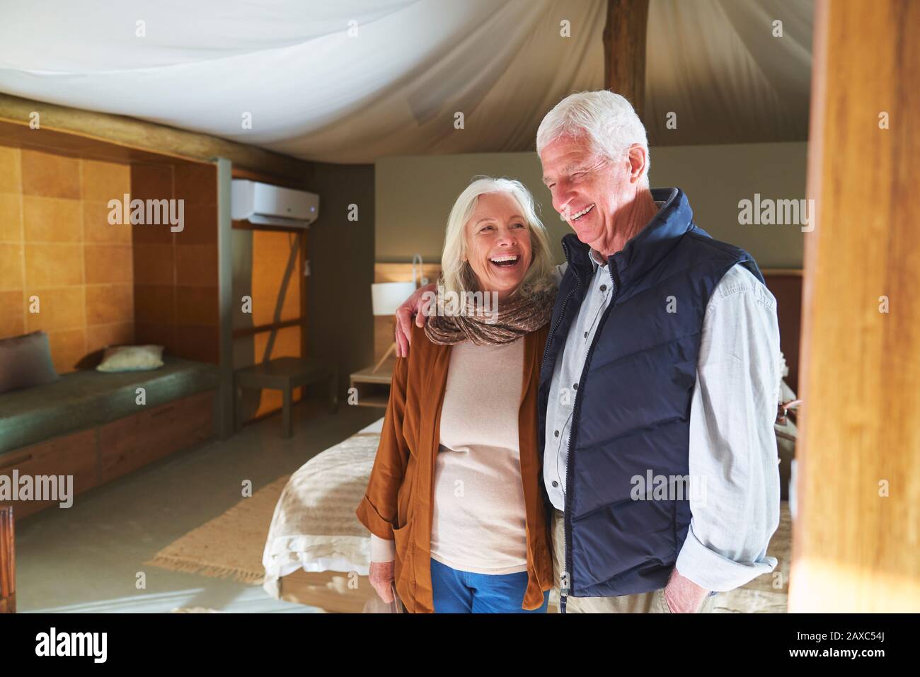 Glückliches älteres Paar lacht im Hotelzimmer Stockfoto