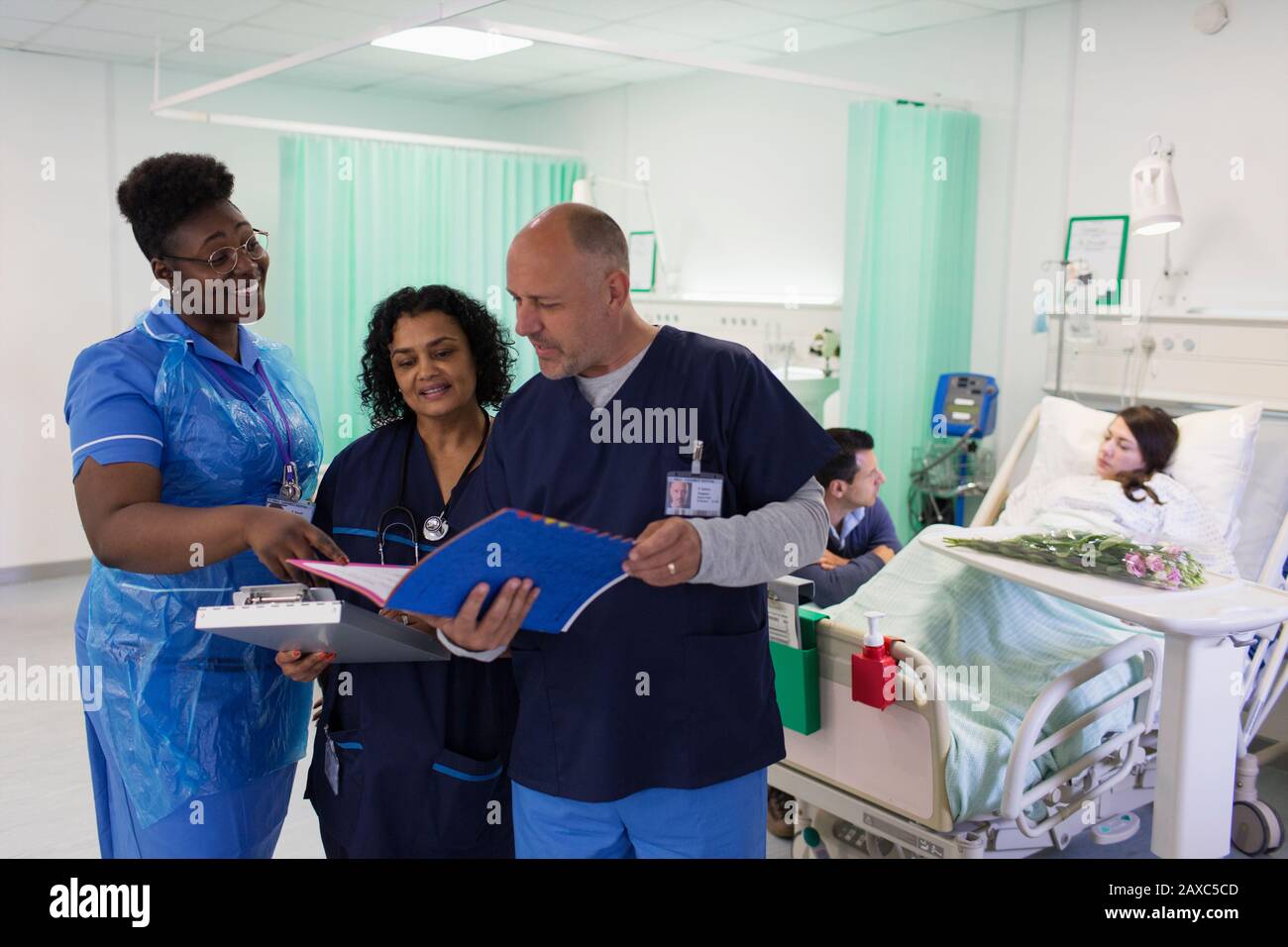 Ärzte und Pfleger mit medizinischen Chart, die Runden führt, beraten in der Krankenstation Stockfoto